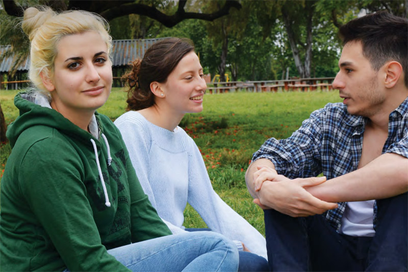 fotografía: tres jóvenes conversando en un parque