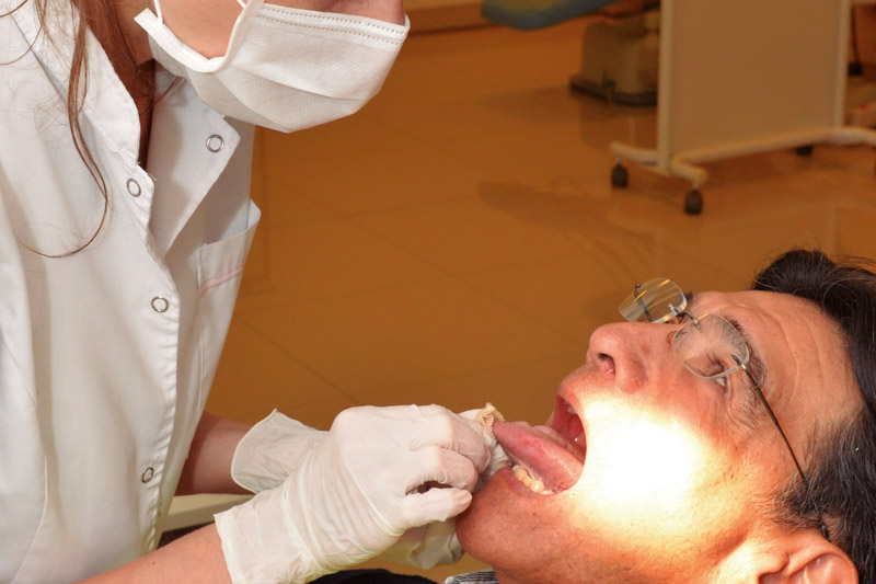 odontóloga atendiendo a paciente de edad mayor